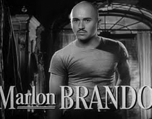 A black and white, noir and mid body image of Tristan looking at the camera with the name 'Marlon Brando' along the bottom on the image.